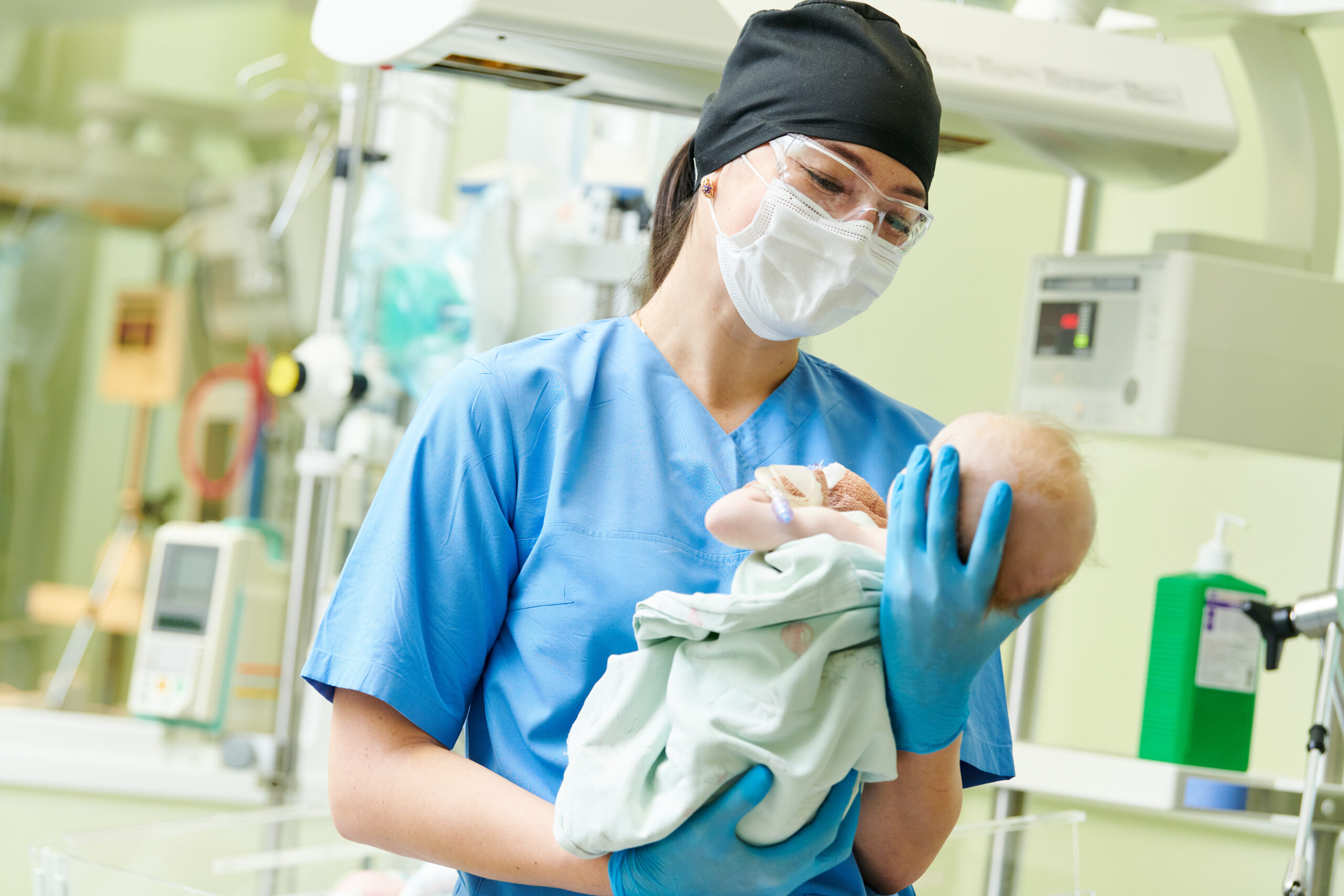 Female nurse holding a newborn baby in hospital. At neonatal resuscitation center